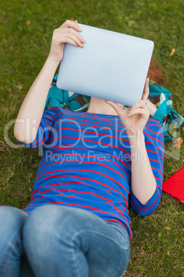 Gorgeous student lying on grass using tablet