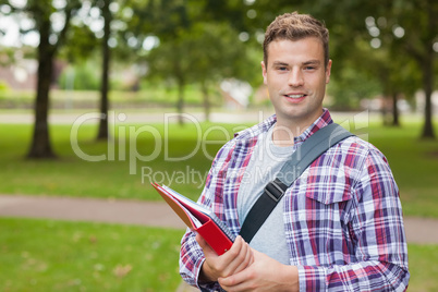 Handsome smiling student carrying folder