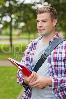 Handsome happy student carrying folder