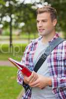 Handsome happy student carrying folder