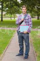 Handsome happy student holding notebook and folder