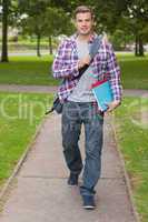 Handsome happy student carrying notebook and folder
