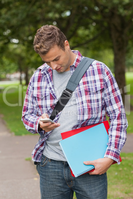 Handsome casual student standing and texting