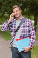 Handsome smiling student standing and phoning