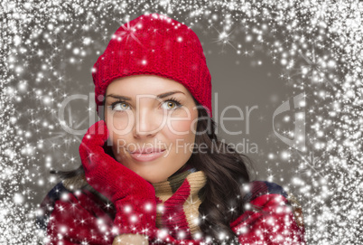 mixed race woman wearing winter hat and gloves enjoys snowfall