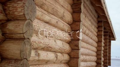 Closer image of the cabin log house ends and some snow covered ground