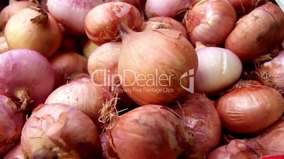 Piled red onions bulbs in a box