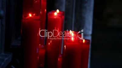 Lighted red candles in a dim-lighted place in church