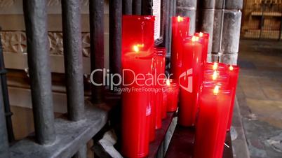 Pile of lighted red candles in church
