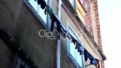 Clothes hanged on the wire the side of a building