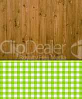 Holzhintergrund mit grün-weißem Tischdeckenmuster