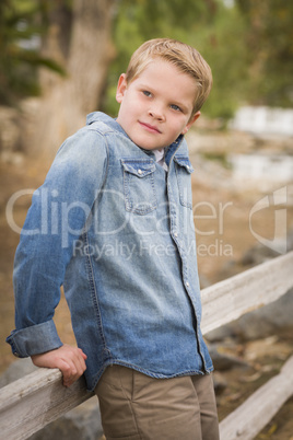 handsome young boy against fence in park