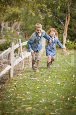 happy young brother and sister running outside