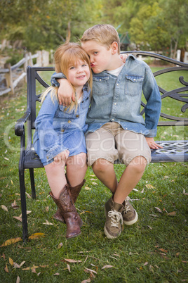 happy young brother and sister sitting together outside