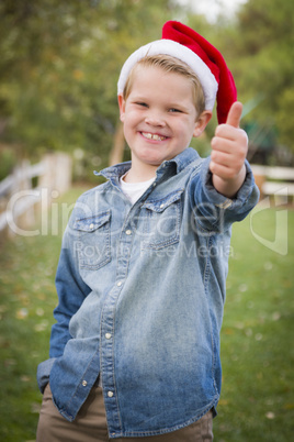 young boy wearing holiday clothing giving a thumbs up outside