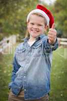 young boy wearing holiday clothing giving a thumbs up outside