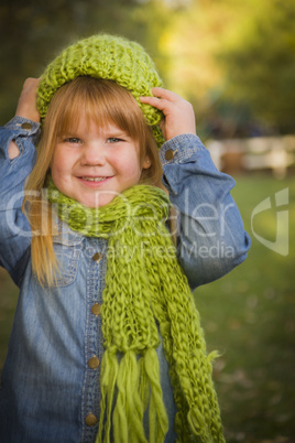 portrait of cute young girl wearing green scarf and hat