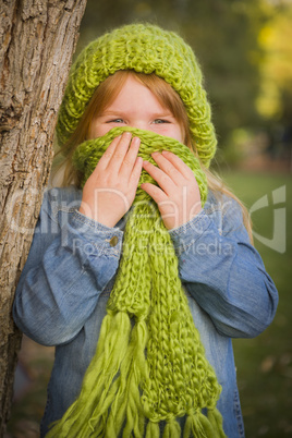 portrait of cute young girl wearing green scarf and hat