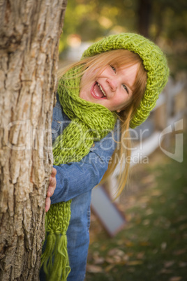 portrait of cute young girl wearing green scarf and hat