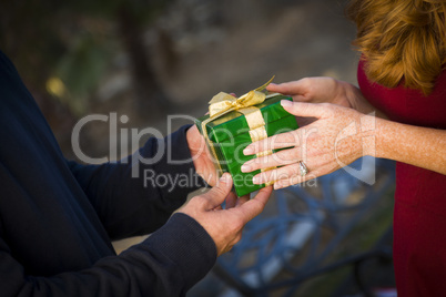 hands of man and woman exchanging christmas gift