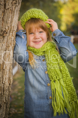 portrait of cute young girl wearing green scarf and hat