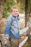 handsome young boy against fence in park