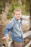 handsome young boy against fence in park