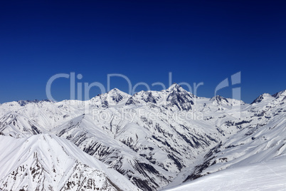 view on off-piste slope, winter snowy mountains and blue clear s