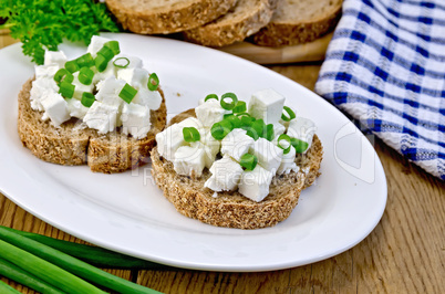bread with feta cheese and green onions on a board