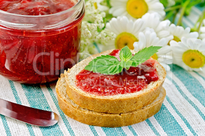 bread with strawberry jam and daisies on a napkin