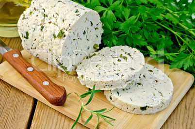 cheese homemade with herbs cut on a board