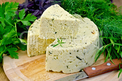 cheese round homemade with herbs and knife on board