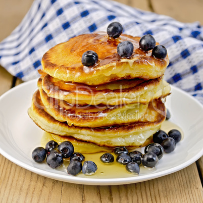 flapjacks with blueberries and honey on the board