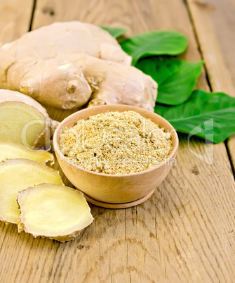 ginger powder in a bowl with the root and leaves