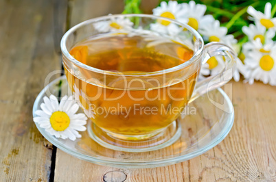 herbal chamomile tea in a glass cup on a board