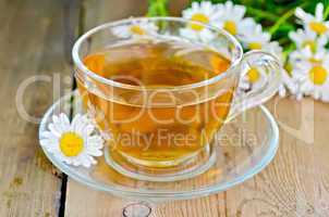 herbal chamomile tea in a glass cup on a board