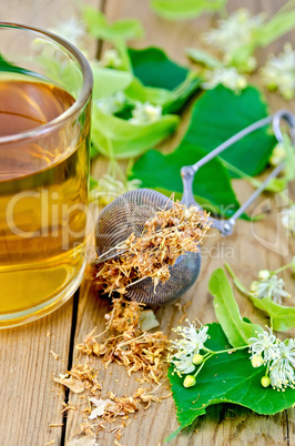 herbal tea from linden flowers in a mug with a strainer on the b