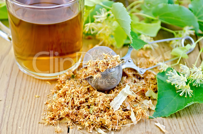 herbal tea from linden flowers in a tea strainer with mug