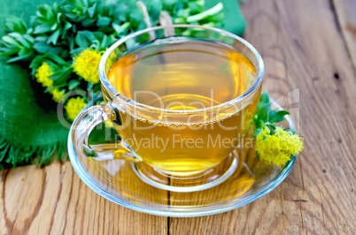 herbal tea in a cup with a bouquet of rhodiola rosea on the boar