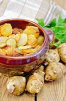 jerusalem artichokes roasted in a clay pot on a board