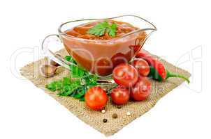 ketchup in a glass gravy boat with vegetables on sacking