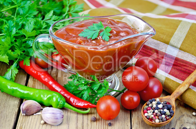 ketchup in a glass gravy boat with vegetables on the board