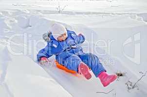 little girl on a sled sliding on snow