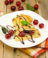 pancakes with cherry and chocolate syrup with a napkin