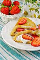 pancakes with strawberries and basket with berries on a napkin