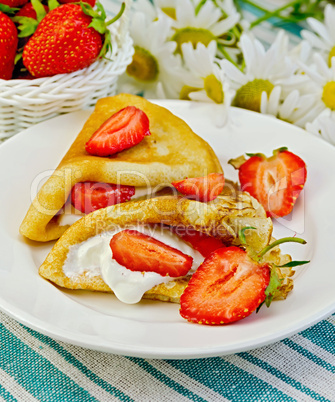 pancakes with strawberries and daisies on a napkin