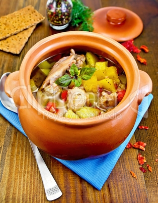 roast chicken in a clay pot on a board