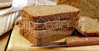 rye homemade bread stacked with a knife on a board
