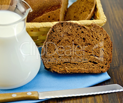 rye homemade bread with milk and a knife on a board