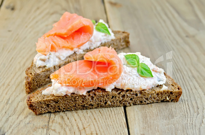 sandwiches on bread with salmon and basil on board